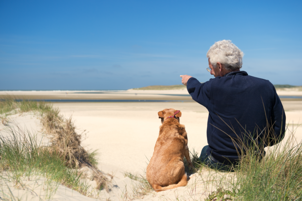 man en hond op strand